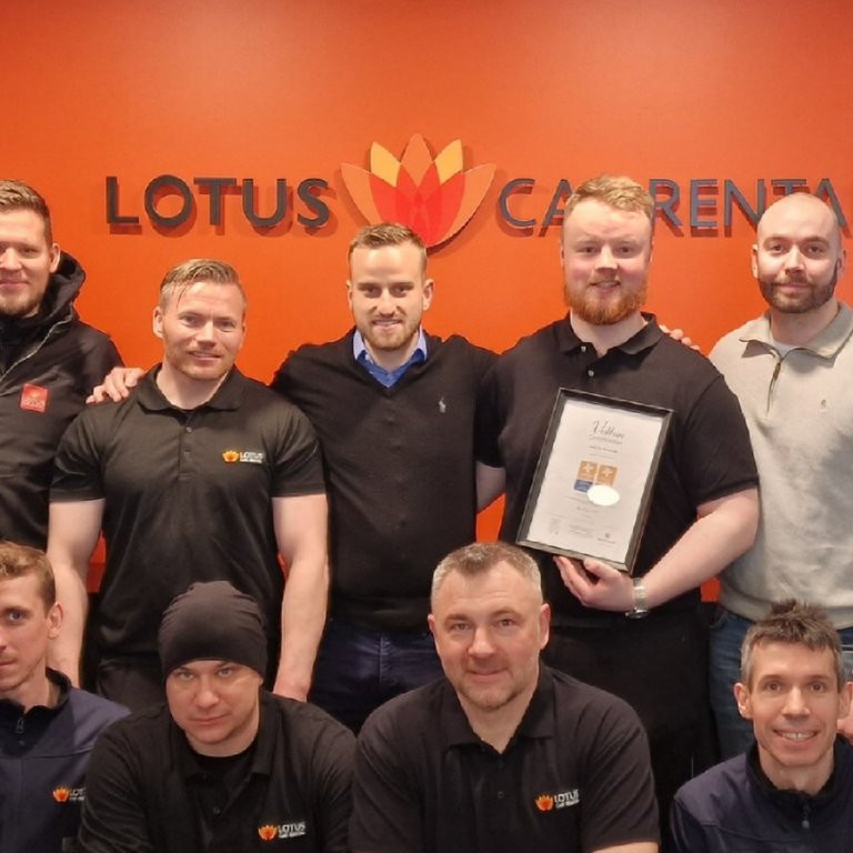 Starfsfólk Lotus Car Rental með vottunarskírteinið